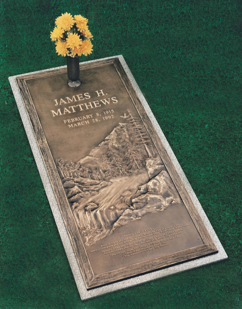 bronze grave marker with yellow flowers